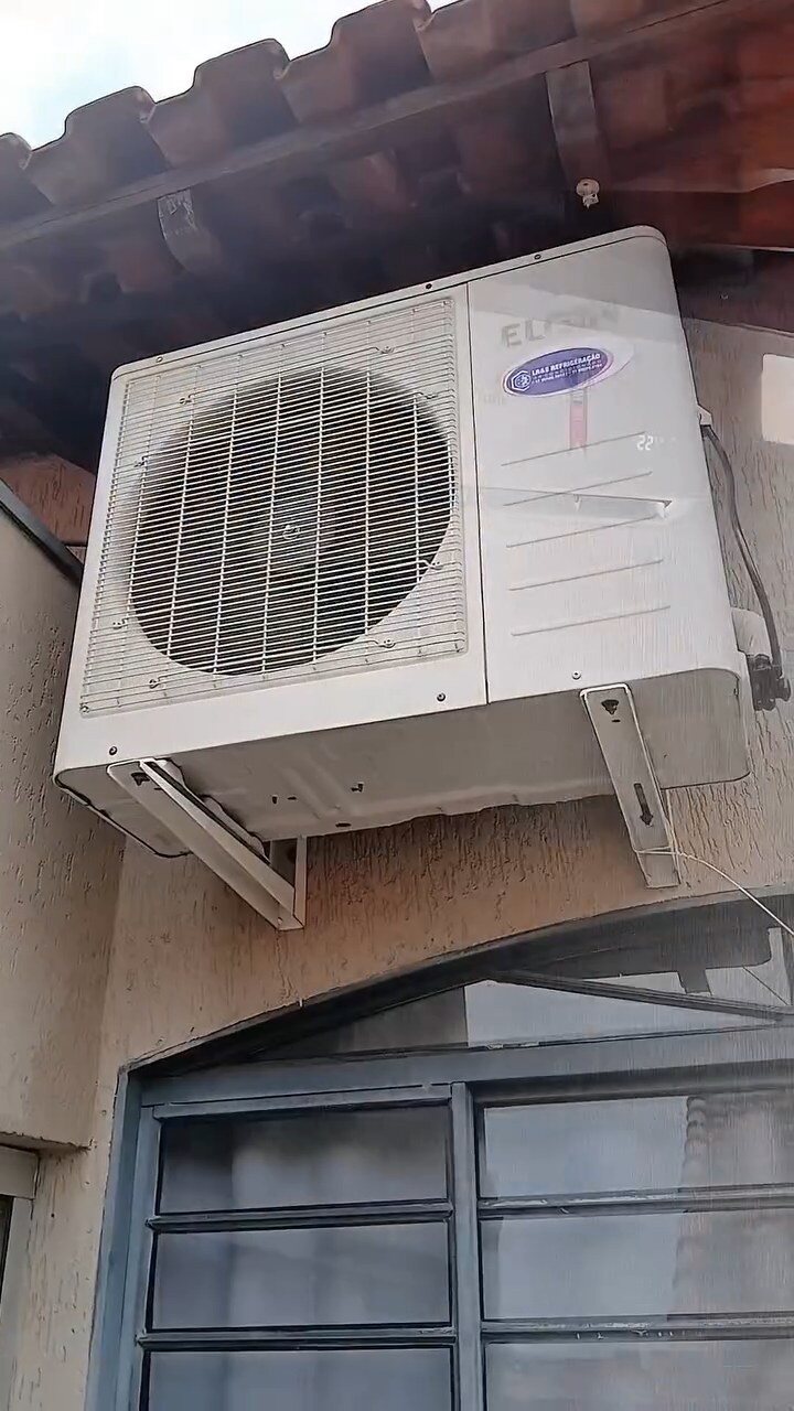 Unidade condensadora instalada na parede externa, mostrada durante registro de serviço da LR&S.